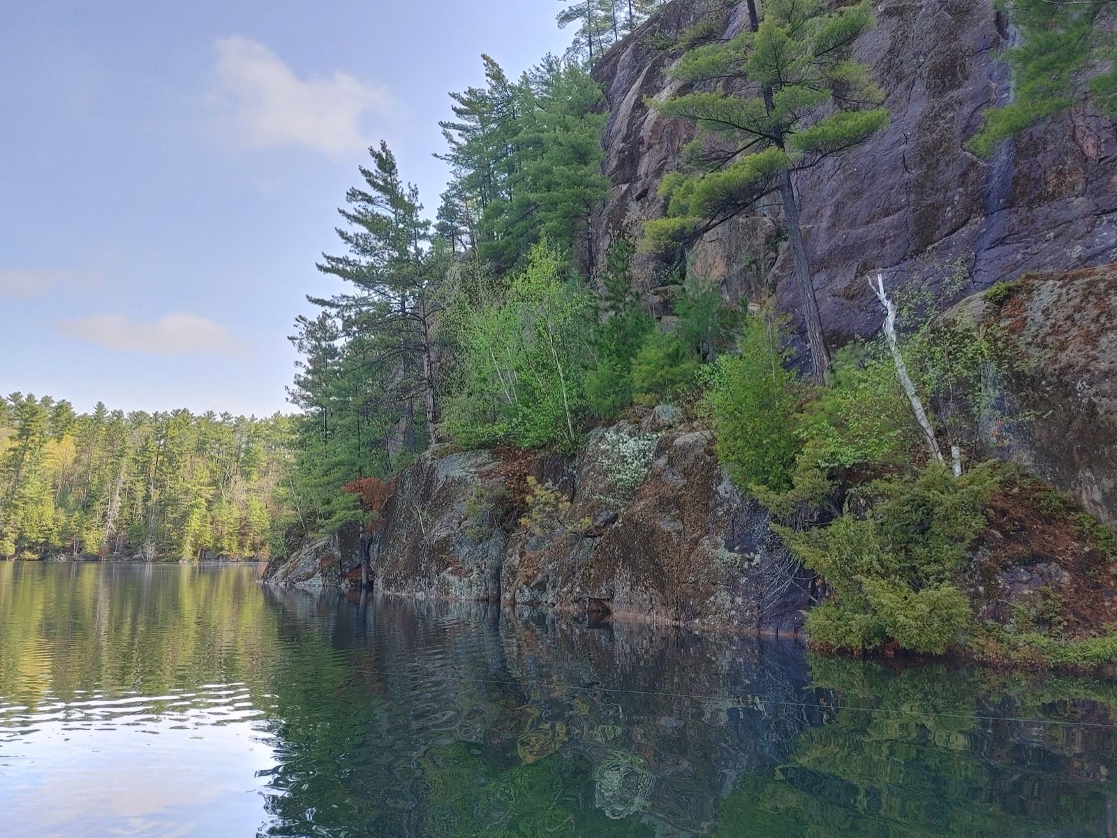 Sheer granite cliffs and pines rising from the clear water of Wabun Lake